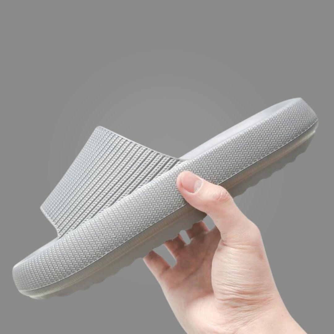 Hand holding light grey Cloud Slide showing ribbed upper and chunky sole