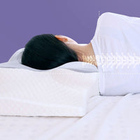 Woman lying on her back on the support pillow, with a graphic overlay showing aligned spine and neck position