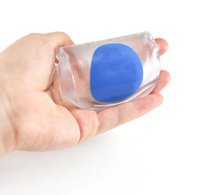 Hand holding a single clear silicone gel heel cup with blue centre cushion, showing flexible compact size