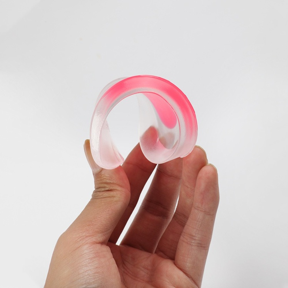 Hand bending a flexible clear silicone heel cup with pink centre, demonstrating material flexibility