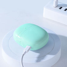 Load image into Gallery viewer, Mint green electric nail clipper charging via USB cable on a white stand near a power board