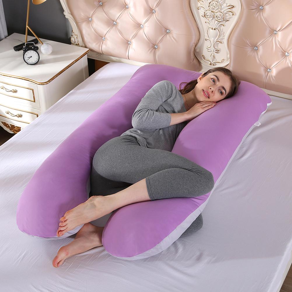 Woman lying on purple Full Body Pillow on bed, side view
