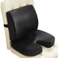 Black memory foam lumbar support and coccyx seat cushion set placed on a cream quilted chair