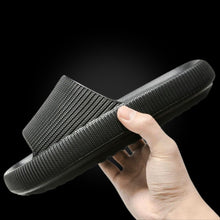Load image into Gallery viewer, Hand holding black Cloud Slide showing thick textured sole, black background
