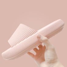 Load image into Gallery viewer, Hand holding pink Cloud Slide showing ribbed strap and sole on pink background
