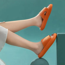 Load image into Gallery viewer, Orange Cloud Slides worn on raised legs against teal background
