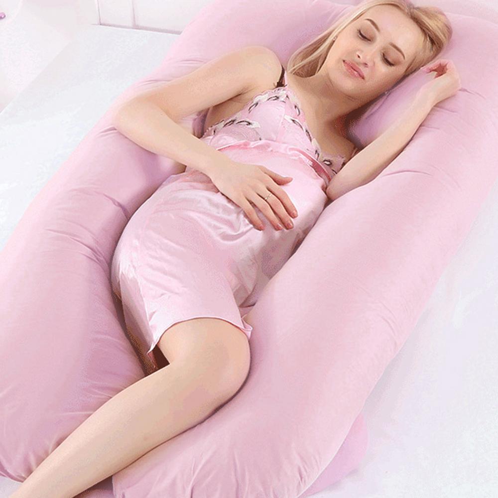 Woman sleeping on her side inside pink U-shape Full Body Pillow