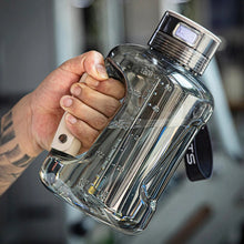 Load image into Gallery viewer, Tattooed hand gripping large clear hydrogen water bottle generator at gym
