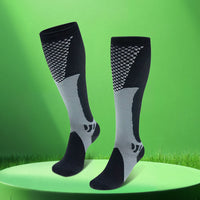 Pair of black grey LegEase Compression Socks on green display platform