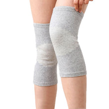 Load image into Gallery viewer, Pair of grey bamboo knee support sleeves on both legs, hand adjusting the top edge
