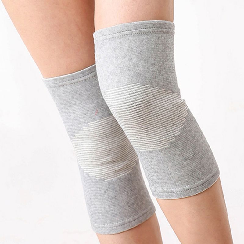 Pair of grey bamboo compression knee supports worn on both legs, showing ribbed pattern
