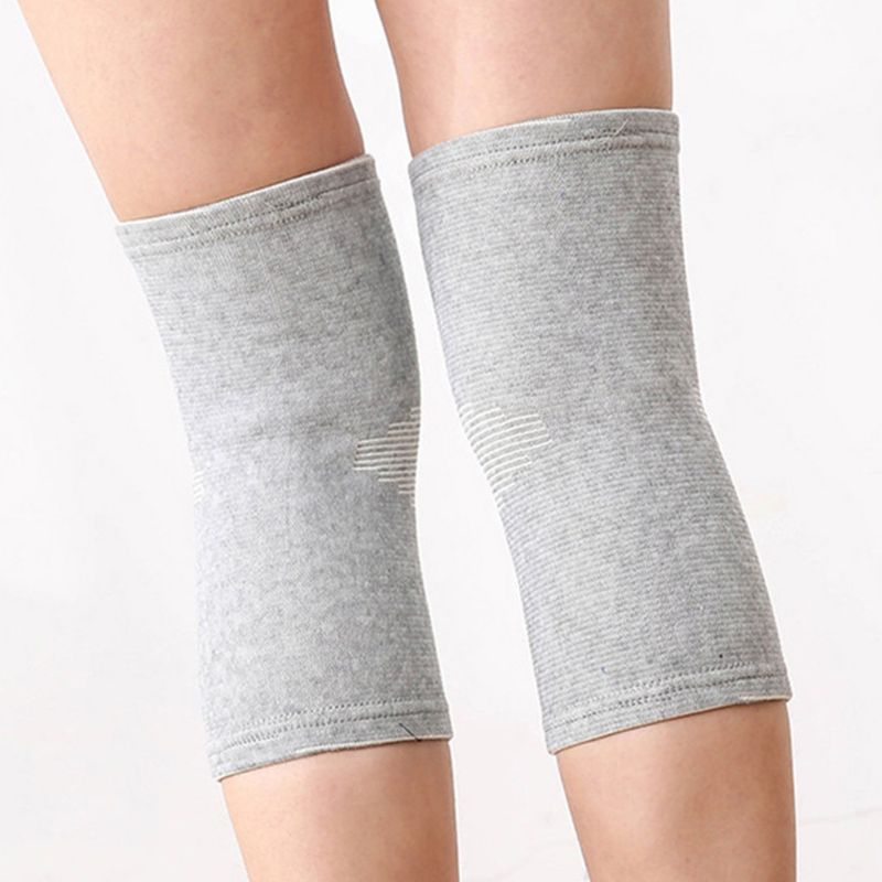 Both legs wearing grey bamboo compression knee supports, showing subtle cross pattern detail