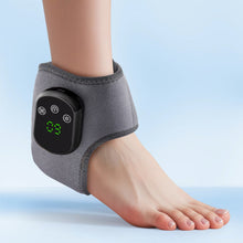 Load image into Gallery viewer, Grey wireless electric heating ankle wrap worn on a bare foot, blue background, green LED display active
