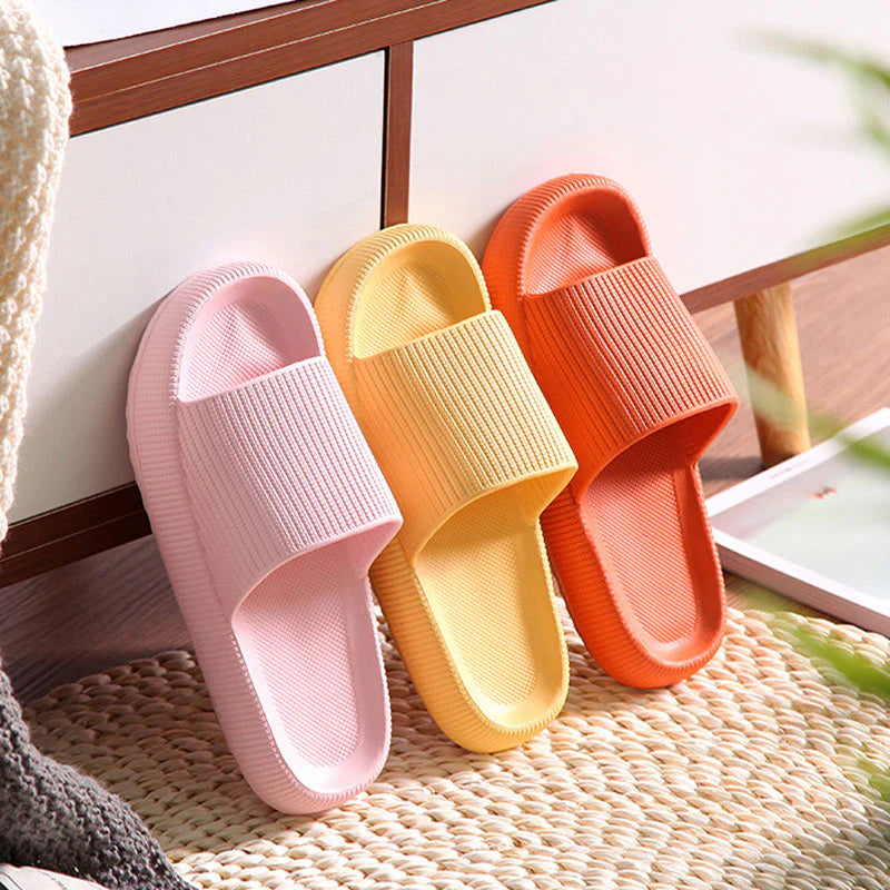 Pink, yellow and orange Cloud Slides trio leaning against cabinet