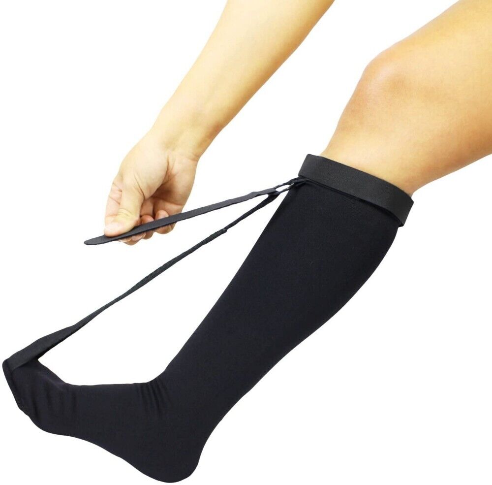 Person adjusting the foot tension strap on a black plantar fasciitis night splint sock, front angle view